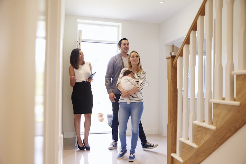 picture of Realtor Showing Young Family Around Property For Sale