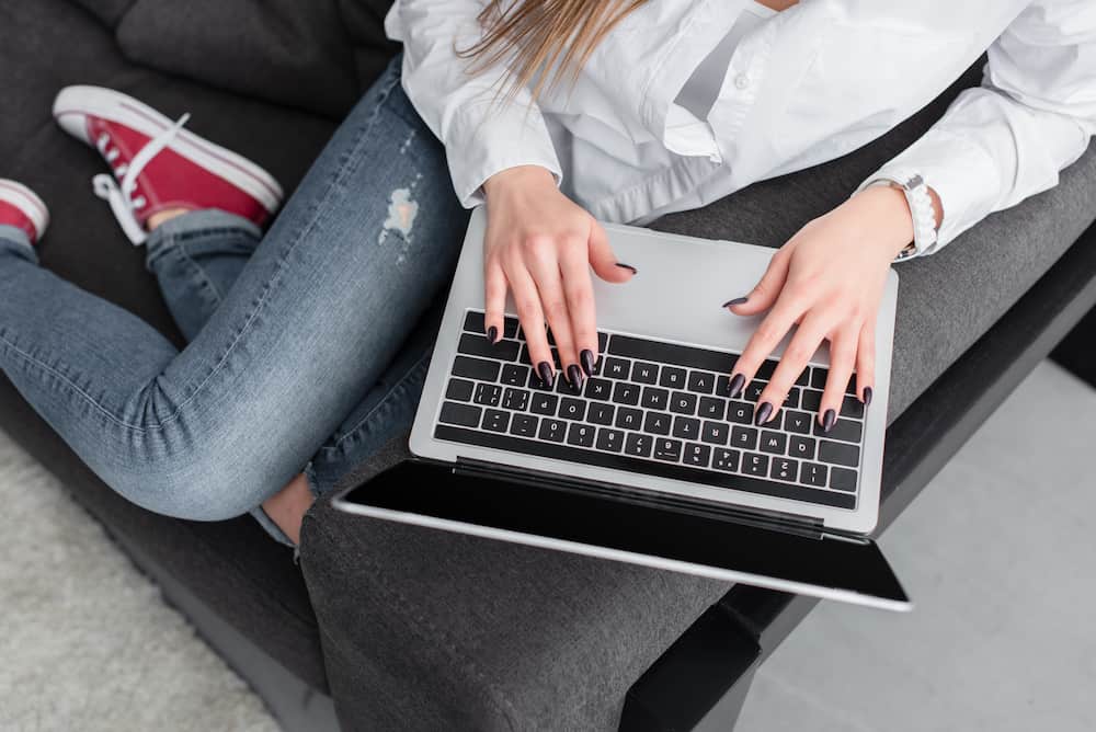 picture of a woman working on a laptop on the couch